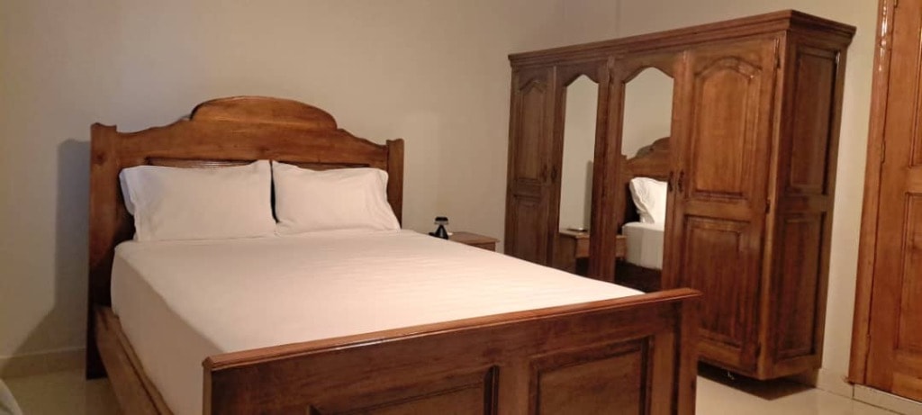 Guest bedroom with solid wood bed frame and matching wardrobe