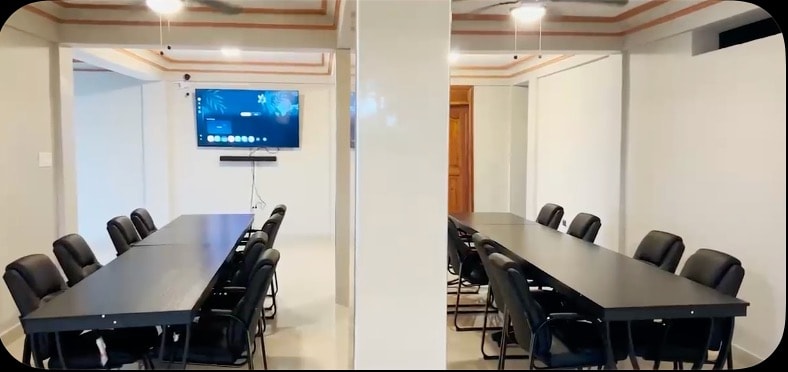 Villa conference room with dual meeting tables and presentation screen