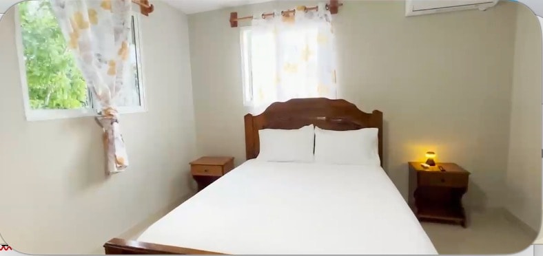 Cozy guest bedroom with wooden furniture and garden window views