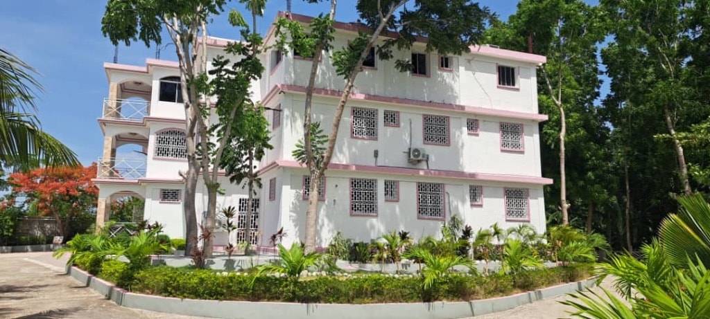 Villa Rêve Créole side view with landscaped gardens and pink trim