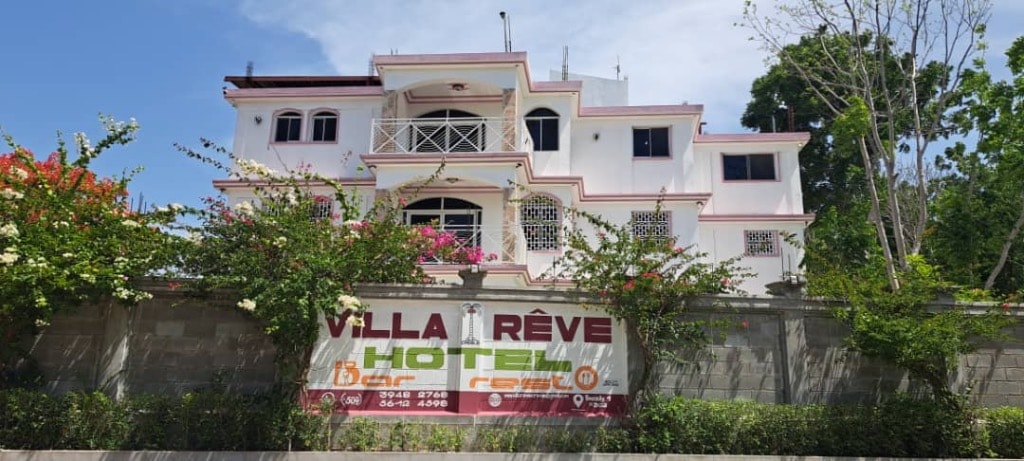Villa Rêve Créole hotel sign with bougainvillea flowers and white facade